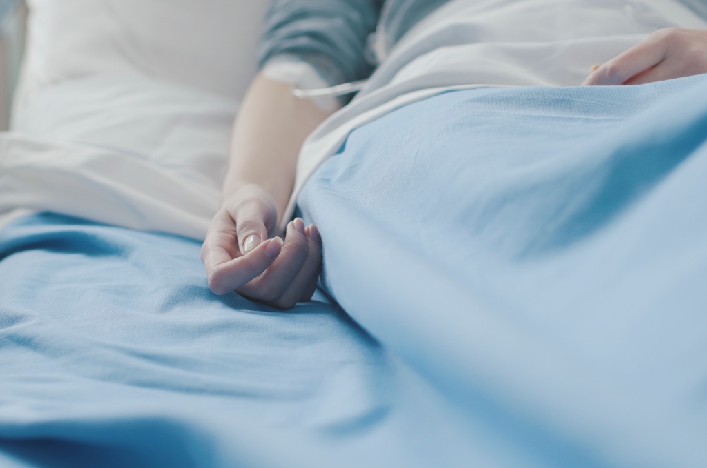 Tod trotz Chemo - blasser Arm mit Kanüle liegt im Krankenbett