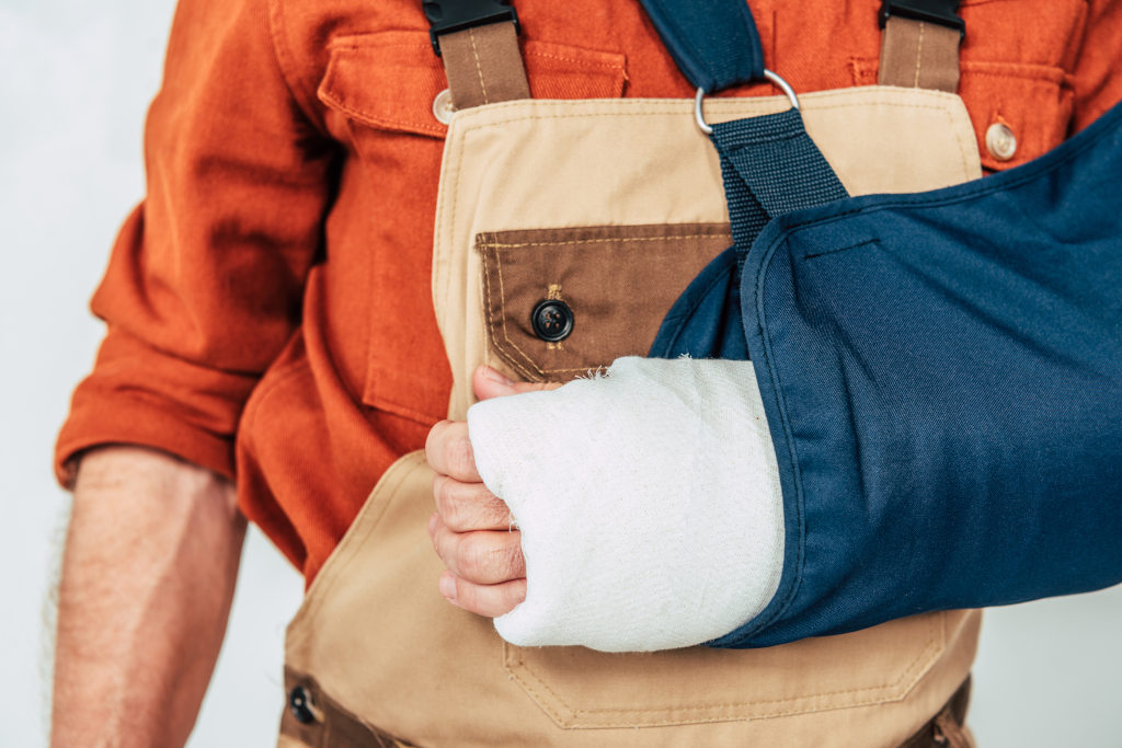 Plötzlich arbeitsunfähig - Mann in Arbeitskleidung hat seinen Arm in Gips